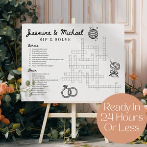 May include: A white sign on an easel with a crossword puzzle titled "Jasmine & Michael SIP & SOLVE." The sign includes wedding-themed graphics like rings, a disco ball, and a cocktail. Text on the sign reads "Ready In 24 Hours Or Less."