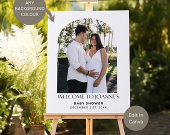 May include: A white welcome sign with a black archway design featuring a photo of a couple. The text reads "Welcome to Joanne's Baby Shower December 21st, 20XX".