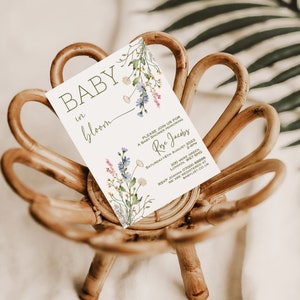 K&ouml;nnte beinhalten: Eine wei&szlig;e Babyparty-Einladung mit einem Blumenmuster und dem Text "BABY in bloom" und "Bitte schlie&szlig;en Sie sich uns zu einer Babyparty zu Ehren von Rose Jacobs an". Die Einladung enth&auml;lt das Datum, die Uhrzeit und den Ort der Veranstaltung sowie die RSVP-Informationen.