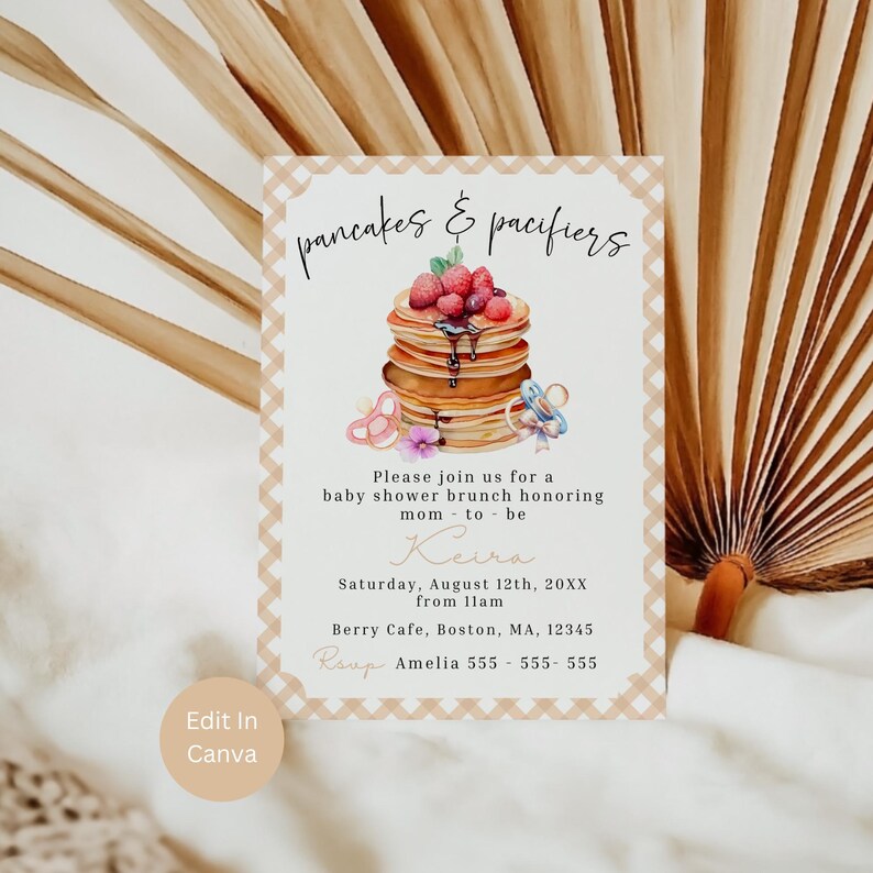 May include: Baby shower invitation with the text "pancakes & pacifiers." The invitation features a stack of pancakes topped with berries and syrup, along with pacifier illustrations. The invitation includes the date, time, location, and RSVP information.