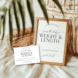 May include: A baby shower game set with a wooden framed sign and a smaller card. The sign reads "guess the baby's WEIGHT & LENGTH" in black script. The card has space for guests to write their guesses. The background is neutral.