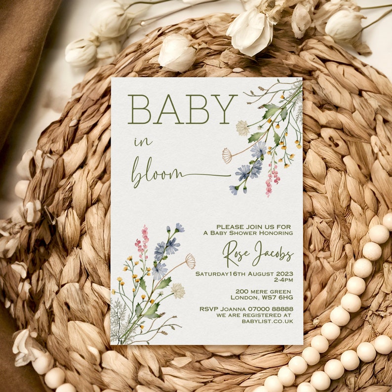 K&ouml;nnte beinhalten: Eine Babyparty-Einladung mit einem floralen Design. Die Einladung lautet "Baby in Bloom" und enth&auml;lt den Namen "Rose Jacobs". Die Babyparty findet am Samstag, den 16. August 2023, von 14:00 bis 16:00 Uhr in der 200 Mere Green, London, WS7 6HG statt. Die RSVP-Nummer lautet 07000 888888. Die Einladung enth&auml;lt auch den Hinweis "Wir sind bei Babylist.co.uk registriert".