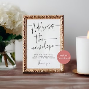 May include: A framed sign with the text "Address the envelope" in elegant black script. The sign also includes the phrases "Save the mom-to-be some time and make yourself the addressee" and "Thank you". A pink circle with "Instant Download" is on the sign.