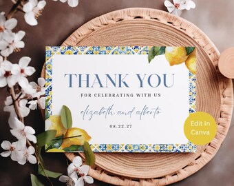 May include: A thank you card with a lemon and floral design. The card features the text "THANK YOU" in blue, along with the names "elizabeth and alberto" and the date "08.22.27". The card is decorated with lemons and a blue and yellow border.