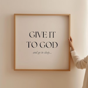 May include: A framed print with the text "GIVE IT TO GOD and go to sleep..." in black lettering on a white background.