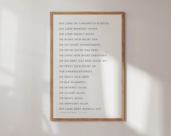 May include: A framed print with a white background and black text. The text is a poem about love, written in German. The poem is titled "Die Liebe" and includes the text "Die Liebe ist langmütig & gütig. Die Liebe beneidet nicht, Die Liebe prahlt nicht. Sie blaht sich nicht auf: Sie ist nicht unanständig. Sie sucht nicht das ihre. Sie lässt sich nicht erbittern, Sie rechnet das Böse nicht zu: Sie freut sich nicht an der Ungerechtigkeit. Sie freut sich aber an der Wahrheit: Sie erträgt alles. Sie glaubt alles. Sie hofft alles. Sie erduldet alles. Die Liebe hört niemals auf. 1 Korinther 13:4-8"