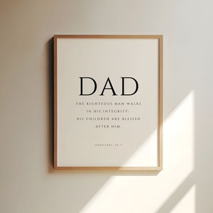 Puede incluir: Una impresi&oacute;n enmarcada con un dise&ntilde;o en blanco y negro. El texto dice "DAD" en letras grandes, seguido de la cita "El hombre justo camina en su integridad: Sus hijos son bendecidos despu&eacute;s de &eacute;l." La cita se atribuye a Proverbios 20:7.