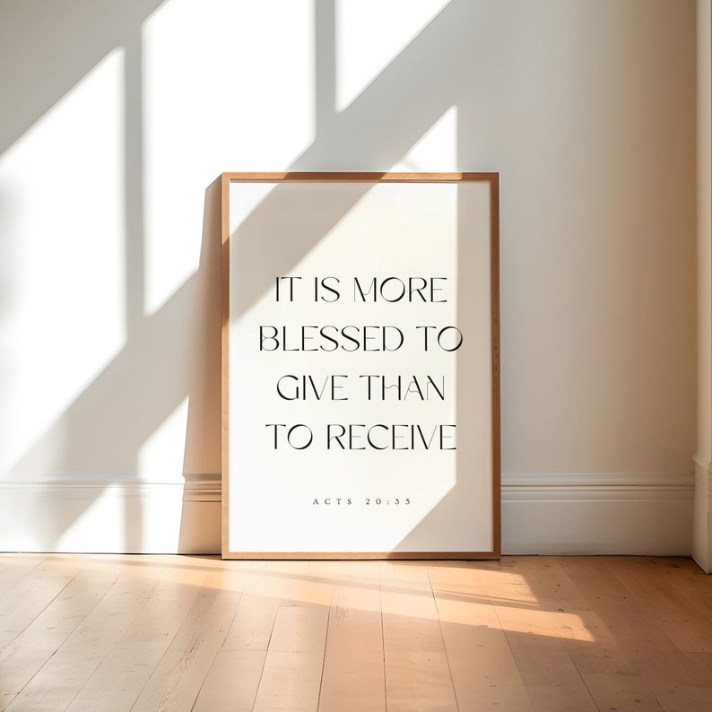 May include: A framed print with the quote "It is more blessed to give than to receive" and the scripture reference "Acts 20:35". The print is on a white background with black text and is framed in a light wood frame.
