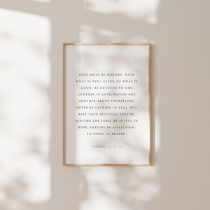 May include: A framed print with a white background and black text. The text is a bible verse from Romans 12:9-12, which reads: "Love must be sincere. Hate what is evil; cling to what is good. Be devoted to one another in love. Honour one another above yourselves. Never be lacking in zeal, but keep your spiritual fervour. Serving the Lord. Be joyful in hope, patient in affliction, faithful in prayer. Romans 12:9-12"