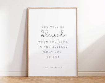 May include: A white framed print with a black and white inspirational quote: "You will be blessed when you come in and blessed when you go out." The quote is attributed to Deuteronomy 28:6.