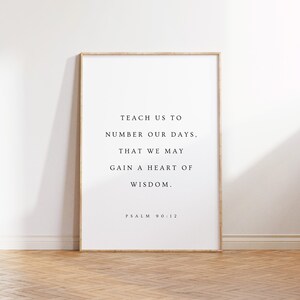 May include: A framed print with a white background and black text. The text reads "TEACH US TO NUMBER OUR DAYS, THAT WE MAY GAIN A HEART OF WISDOM. PSALM 90:12".