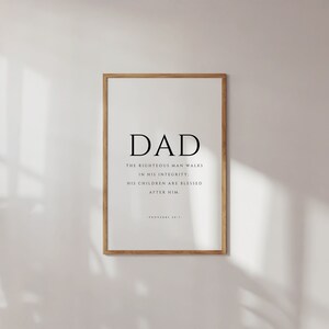 Puede incluir: Una impresi&oacute;n enmarcada con la palabra "DAD" en letras grandes y una cita de Proverbios 20:7: "El hombre justo anda en su integridad: Sus hijos son bendecidos despu&eacute;s de &eacute;l."