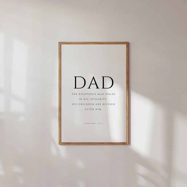 Puede incluir: Una impresi&oacute;n enmarcada con la palabra "DAD" en letras grandes y una cita de Proverbios 20:7: "El hombre justo anda en su integridad: Sus hijos son bendecidos despu&eacute;s de &eacute;l."