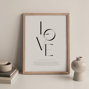 Op de afbeelding: Een zwart-witte printbare kunstprint met het woord "LOVE" in een gestileerd lettertype. De print bevat een Bijbelvers uit 1 Korintiërs 13:4-8 over de kenmerken van liefde.
