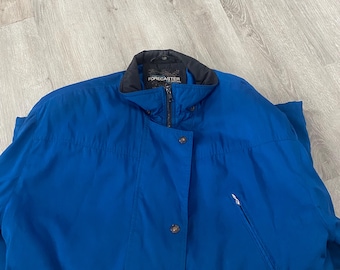 May include: A blue jacket with a black collar and a zipper closure. The jacket has a button on the front and a pocket on the right side. The label on the jacket reads "FORECASTER".