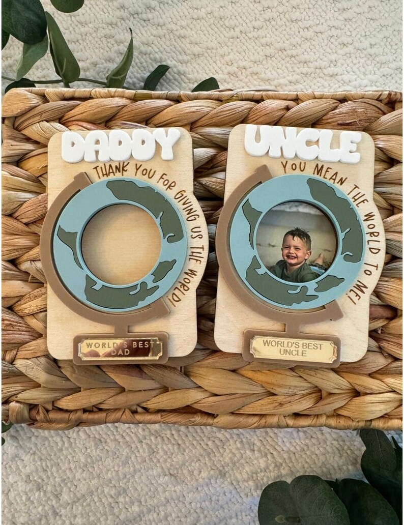 May include: Two wooden photo frames with a globe design. One says "Daddy" and "Thank You For Giving Us The World!" The other says "Uncle" and "You Mean The World To Me!" Both have "World's Best" plaques.