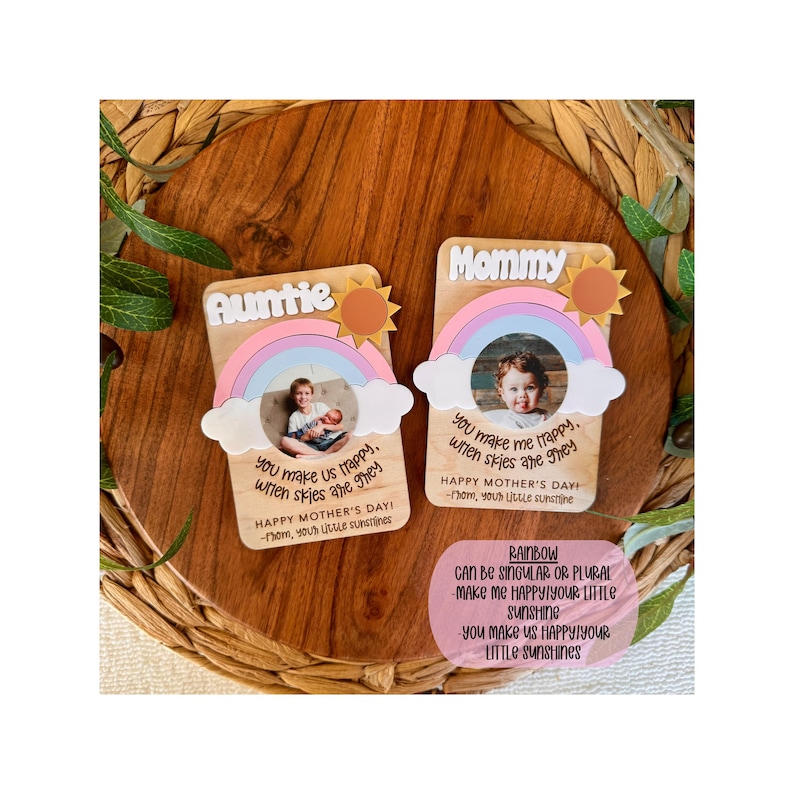 May include: Two wooden Mother's Day cards with rainbow and sun designs. One card says "Auntie" and the other says "Mommy". Each card has a photo and a message: "You make us happy when skies are grey."