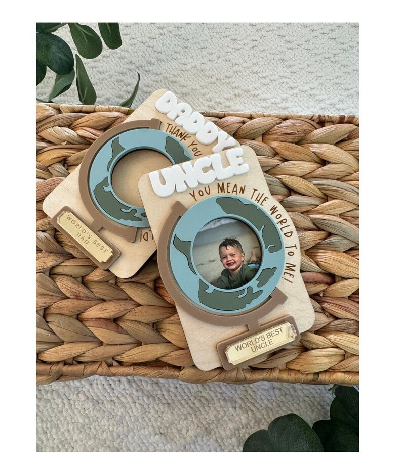 May include: Two wooden photo frames with globe designs. One says "Daddy, Thank You" and "World's Best Dad." The other says "Uncle, You Mean The World To Me!" and "World's Best Uncle."