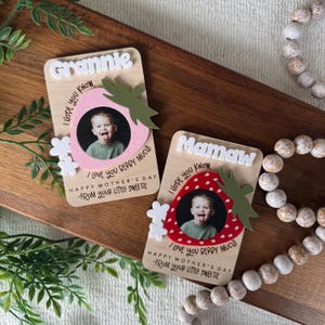 May include: Two wooden Mother's Day gifts with photos of a child. One says "Grannie" and the other says "Mamaw" in white letters. Each has a strawberry design with the text "I love you berry much!" and "Happy Mother's Day - From your little sweetie."