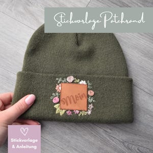 Könnte beinhalten: Eine grüne Mütze mit einem braunen Lederpatch, auf dem "Moin" steht, umgeben von gestickten Blumen.