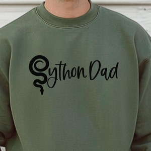 Peut inclure: Un sweat-shirt vert avec un logo de serpent noir et le texte "Python Dad" imprimé sur le devant.