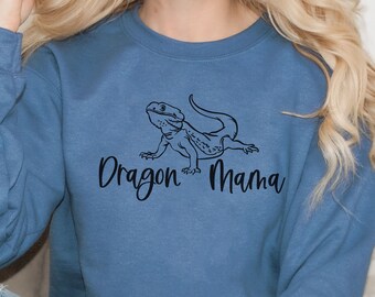 May include: A blue sweatshirt featuring a black outline of a bearded dragon and the text "Dragon Mama".
