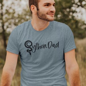 May include: A heather blue t-shirt with a black python logo and the text "Python Dad" printed on the front.