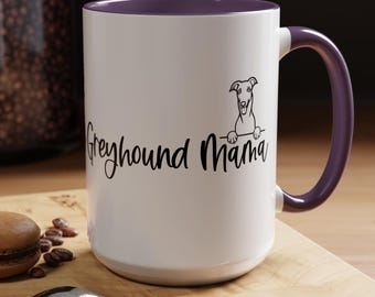 Könnte beinhalten: Weiße Keramik-Kaffeetasse mit lilafarbenen Rand und Henkel. Die Tasse zeigt eine Schwarzweißillustration eines Windhundes, der über den Rand schaut, und den Text "Greyhound Mama" in schwarzer Kursivschrift.