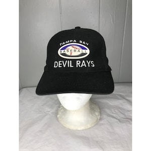 Peut inclure: Casquette de baseball noire avec l'inscription blanche "TAMPA BAY BASEBALL DEVIL RAYS". La casquette a une visière incurvée et un logo de baseball. La casquette est présentée sur une tête de mannequin blanche.