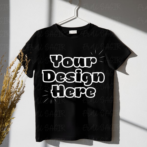 Modern Black T-Shirt Mockup on White Wall with Natural Shadow and Decor, Ideal for Apparel Brands and Graphic T-Shirt Listings