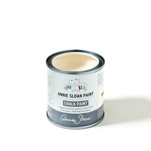 May include: A white can of Annie Sloan Chalk Paint. The can has a label with the Annie Sloan logo and the text "Chalk Paint" and "Annie Sloan Paint".