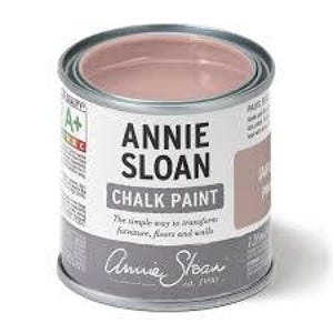 May include: A partially open can of Annie Sloan Chalk Paint in a muted pink color, labeled "Jasmine." The can is silver with white and gray labels, and the text "Annie Sloan Chalk Paint" is prominently displayed. The can contains 120 ml of paint.