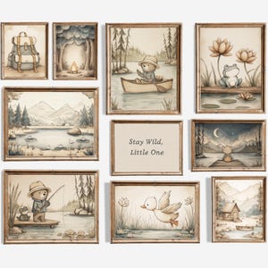Può includere: Una collezione di stampe artistiche ad acquerello incorniciate a tema bosco. Le stampe raffigurano un orso, una rana, un'anatra e uno zaino. Una stampa ha il testo "Stay Wild, Little One". La tavolozza dei colori comprende marroni, verdi e blu.