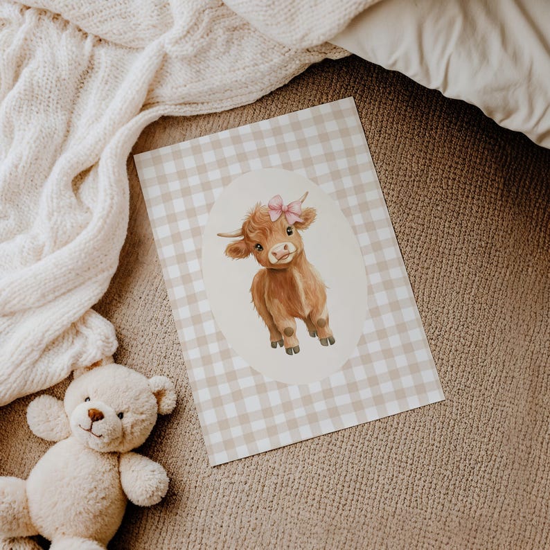 May include: A brown and white highland cow with a pink bow on its head. The cow is standing on a white and brown gingham background.