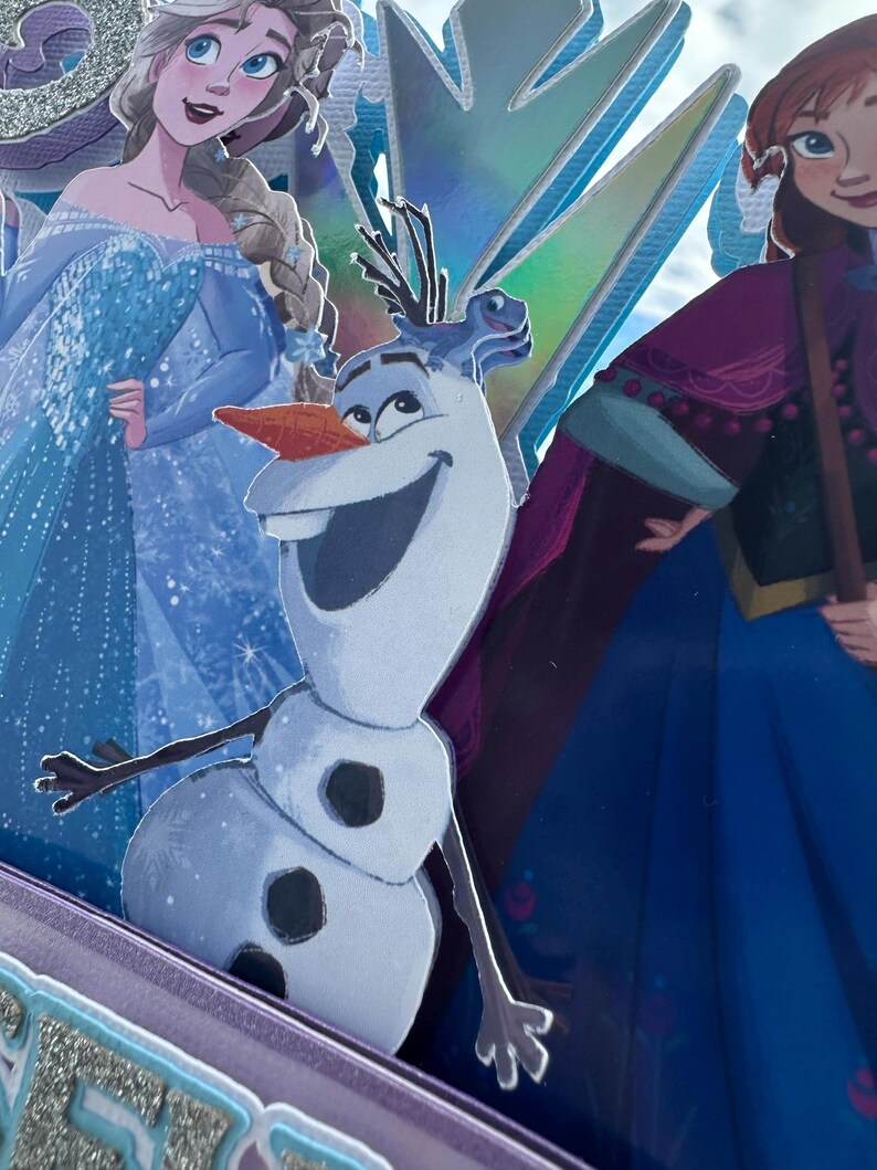 May include: A layered image featuring characters from the animated film "Frozen." Olaf the snowman is in the foreground, with Elsa and Anna in the background. The image has a glittery, iridescent finish with shades of blue, purple, and silver.