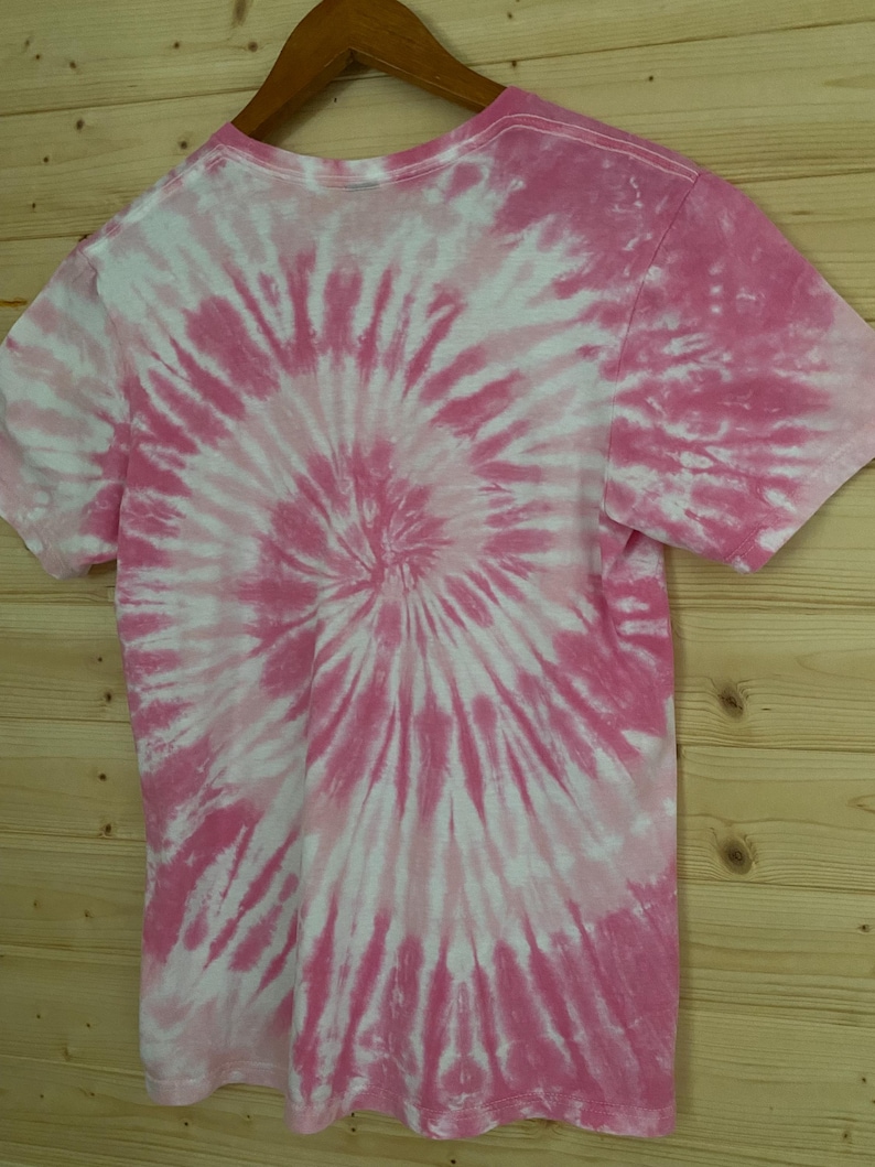 May include: Pink and white tie-dye t-shirt with a spiral pattern.