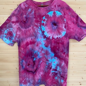 May include: A tie-dye t-shirt with a pink, blue, and purple swirl pattern.