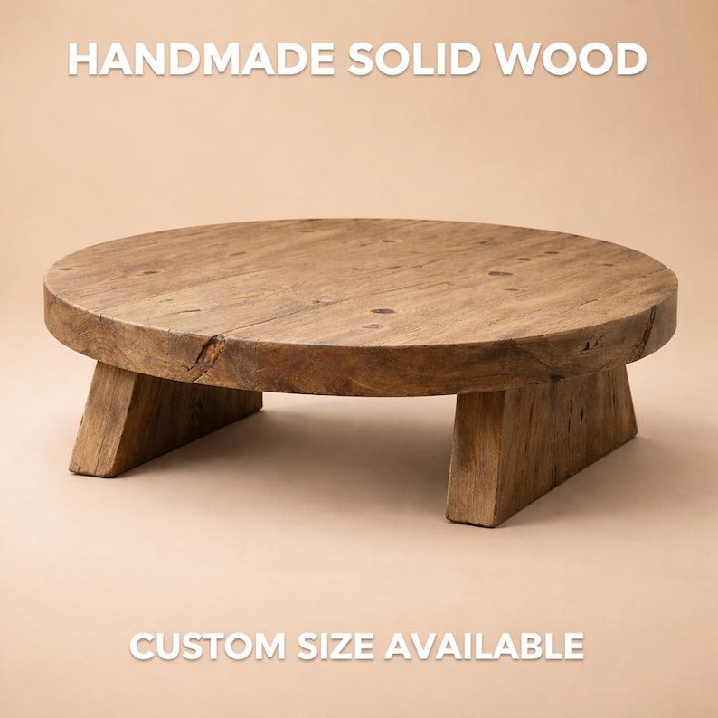 May include: A handmade, solid wood, round table with three angled legs. The table is a natural wood colour with visible grain and knots. The text "CUSTOM SIZE AVAILABLE" is at the bottom of the image.