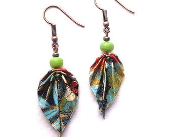 May include: A pair of dangle earrings with a green bead and a leaf-shaped charm made of colorful patterned fabric.