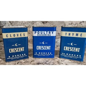 May include: Three vintage blue spice tins with white lettering. The tins are labeled "Cloves", "Poultry Seasoning", and "Thyme". Each tin has the "Crescent" brand name and the weight in ounces.