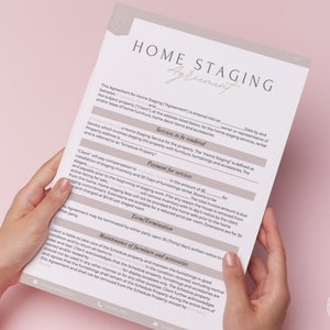 May include: A close-up of a home staging agreement document. The document outlines the services to be rendered, payment for services, term termination, and maintenance of furniture and accessories. The document is held in the hands of a person.