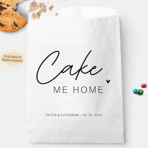 Op de afbeelding: Een witte papieren cadeauzak met zwarte tekst die "Cake Me Home" luidt met een klein hartje. De zak bevat ook de tekst "Peter & Catherine | 05. 23. 2024".