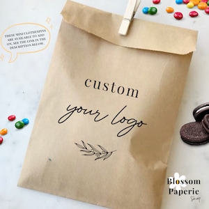 May include: A brown paper bag with the text "custom your logo" and a small sprig of leaves. The text "Blossom Paperie Shop" is also visible at the bottom of the bag.