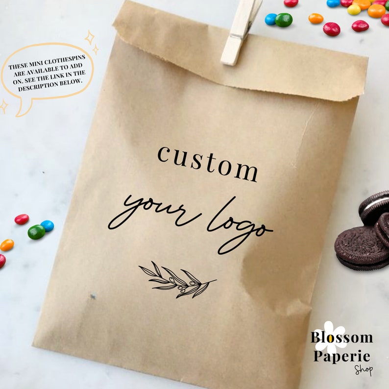 May include: A brown paper bag with the text "custom your logo" and a small sprig of leaves. The text "Blossom Paperie Shop" is also visible at the bottom of the bag.