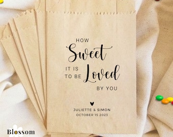 May include: Brown paper bags with a wedding favour message that reads "How Sweet It Is To Be Loved By You" with the couple's names and wedding date below.