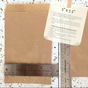May include: A brown paper bag measuring 5 inches by 7.5 inches. The bag is unlined and biodegradable. The text on the bag reads "These bags are un-lined, and are NOT grease-proof. Without the wax lining, these ecofriendly favors are fully recyclable, and also biodegradable!" and "What can you fit in our favor bags?" followed by a list of items that can fit in the bag.