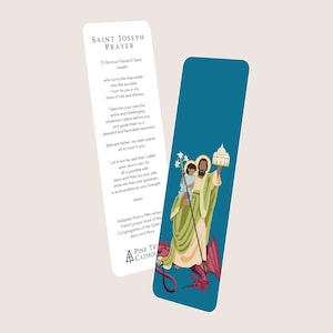 Può includere: Due segnalibri. Un segnalibro bianco presenta il testo "Saint Joseph Prayer". L'altro segnalibro è verde acqua e presenta un'illustrazione di San Giuseppe che tiene in braccio un bambino e un edificio. L'illustrazione è nei toni del verde, giallo e rosso.