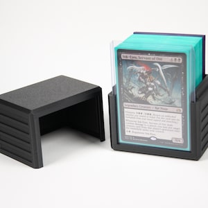 Op de afbeelding: Zwarte kaarthouder met een bijpassende kleine standaard. De kaarthouder is gevuld met kaarten in sleeves. De kaarthouder en standaard zijn gemaakt van matzwart materiaal. De kaarten zijn zichtbaar en voorzien van een fantasie-illustratie.