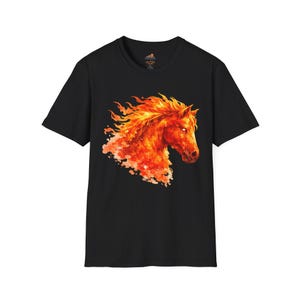 Könnte beinhalten: Schwarzes T-Shirt mit einem feurigen Pferdekopf-Design. Die Mähne und der Körper des Pferdes sind in Orange- und Rottönen dargestellt, mit einem flammenartigen Aussehen. Das Kunstwerk ist auf dem Shirt zentriert.