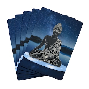 May include: A stack of cards with a blue background and a white silhouette of a meditating Buddha against a starry night sky.